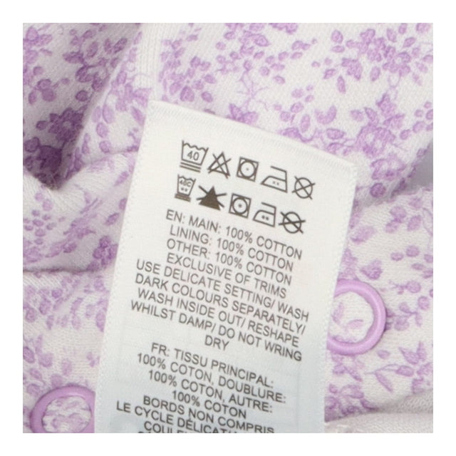 White sleepsuit with purple floral and frill colla