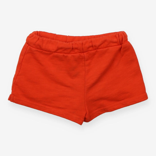 Orange jersey shorts with green pompom edging